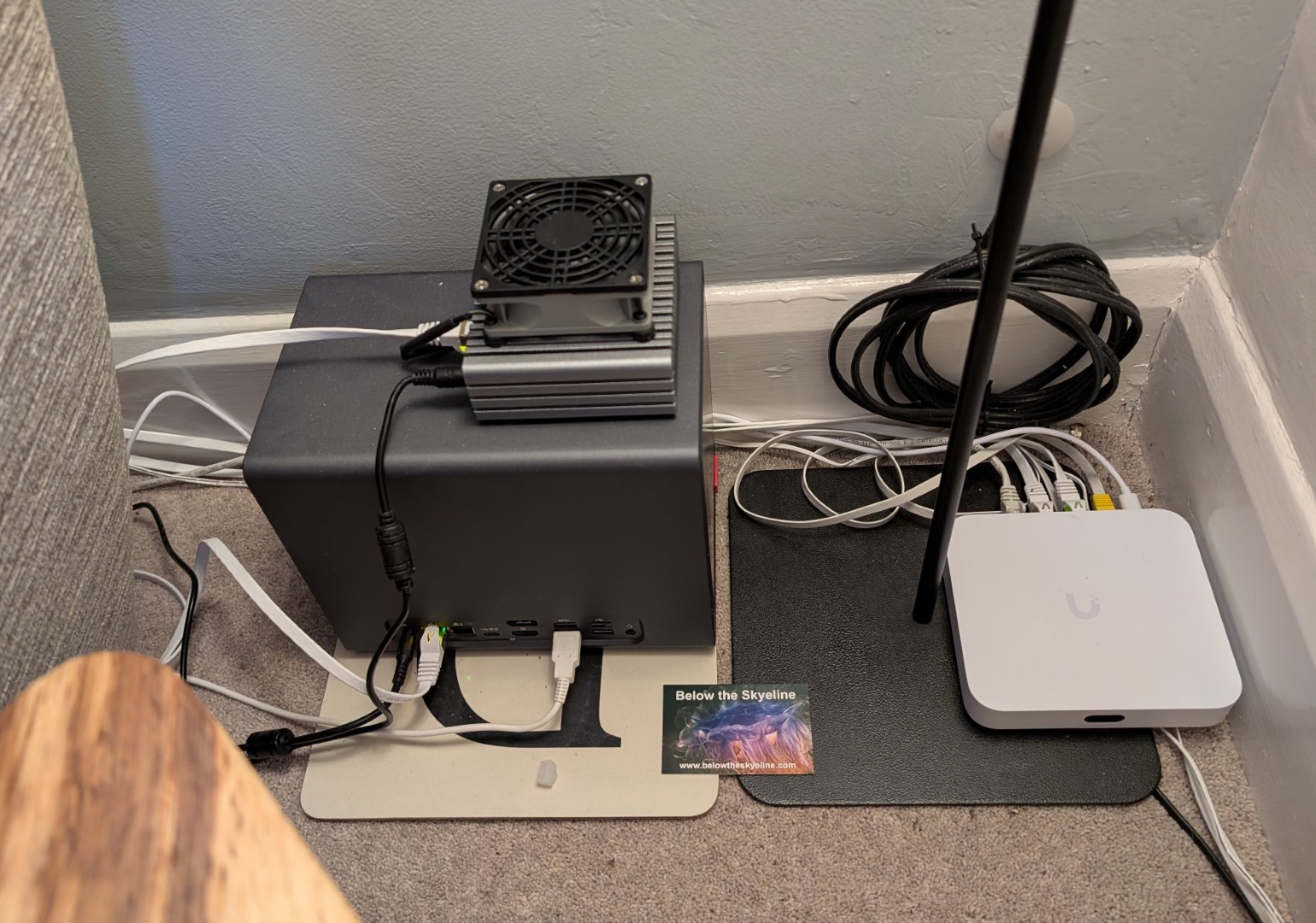 My self-hosting setup, showing two small computers on top of each other, in a corner